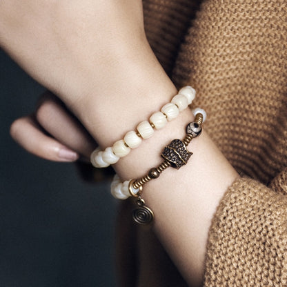 Bracelet tibétain en perles d’os de yak à deux rangées avec charme en cuivre martelé