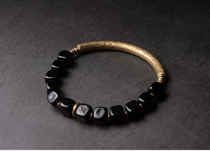 Kubisches Armband aus schwarzem Obsidianstein mit Messinganhänger