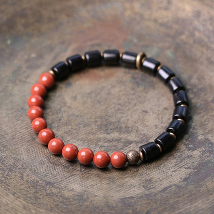 Bracelet en perles de bois et de pierre d'ébène, agate rouge, mousse et fleur