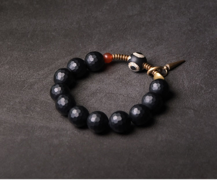 Bracelet de perles d'onyx à facettes avec perle tibétaine anti-mal