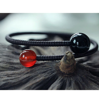 Bracelet tressé en corde tibétaine avec perles d'onyx et d'agate rouge